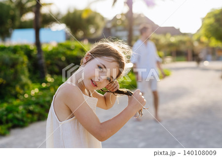 Young girl taking care of her wet hair during summer vacation. 140108009