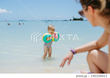 Mother playing in sea water with little daughter. Mother playing in sea water with little daughter. 140108021
