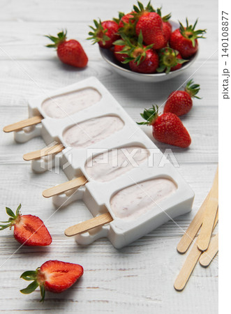 Making strawberry frozen yogurt popsicles for a healthy summer dessert Making strawberry frozen yogurt popsicles for a healthy summer dessert 140108877
