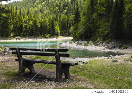 Serene wooden bench overlooking the Gruner See, Austria, illustrating the impact of climate variability on mountain ecosystems 140108892