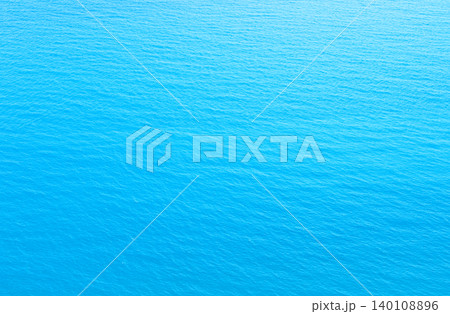 Aerial view of tranquil turquoise ocean surface displaying subtle wave patterns and a gradient of blue hues Aerial view of tranquil turquoise ocean surface displaying subtle wave patterns and a gradient of blue hues 140108896