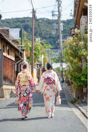 伝統的な古い町並みを歩く二人の着物姿の女性の後ろ姿。京都、日本 伝統的な古い町並みを歩く二人の着物姿の女性の後ろ姿。京都、日本 140109334