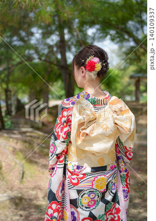 新緑の庭園を見つめる色鮮やかな着物姿の女性の後ろ姿。京都、日本 新緑の庭園を見つめる色鮮やかな着物姿の女性の後ろ姿。京都、日本 140109337
