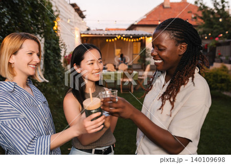 Diverse women friends toasting at outdoor backyard party Diverse women friends toasting at outdoor backyard party 140109698