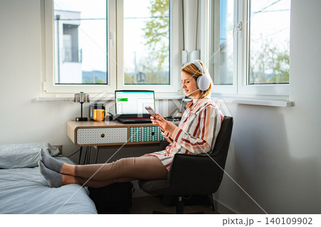 Woman working remotely at home office using laptop Woman working remotely at home office using laptop 140109902