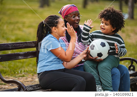 Family enjoying playful interaction with soccer ball in park Family enjoying playful interaction with soccer ball in park 140109921