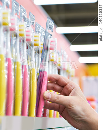 Toothbrush in package in hand in store 140110337