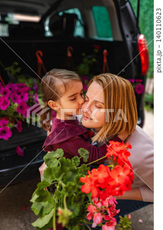 Mother and daughter bonding with flowers and plants 140110623