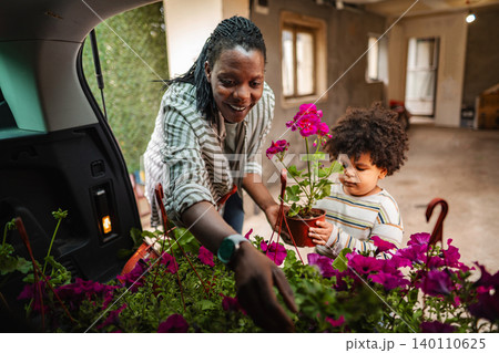 Mother and child getting flowers from car trunk Mother and child getting flowers from car trunk 140110625