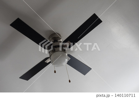 Modern dirty ceiling fan with light fixture mounted on white ceiling 140110711