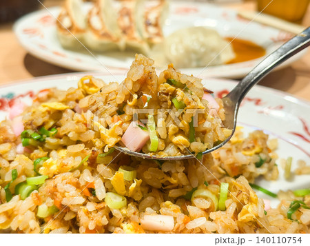 ラーメン屋で食べる炒飯。米とチャーシューや卵や葱などの具材で作る中華風料理。スプーンで持ち上げてる。 ラーメン屋で食べる炒飯。米とチャーシューや卵や葱などの具材で作る中華風料理。スプーンで持ち上げてる。 140110754