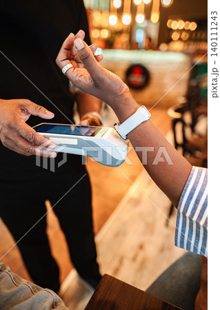 Customer using smartwatch for contactless payment at coffee shop Customer using smartwatch for contactless payment at coffee shop 140111243