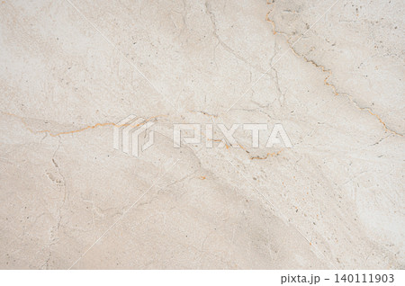 A beige marble background with subtle brown veining and a natural stone texture. A beige marble background with subtle brown veining and a natural stone texture. 140111903