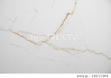 A white marble background with subtle brown veining and a natural stone texture. 140111909