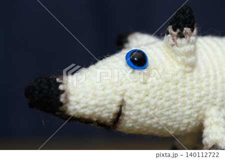 Close-Up of White Hand-Knitted Dog on Dark Background 140112722