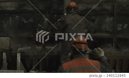 Mold Technicians In Bright Vests And Helmets Working Carefully Beside Hightemperature Furnace . Stock clip Mold Technicians In Bright Vests And Helmets Working Carefully Beside Hightemperature Furnace . Stock clip 140112845
