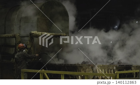 Worker Amidst Steam Near Furnace. Industrial Environment With Worker Surrounded By Smoke And Machinery. Stock Clip 140112863