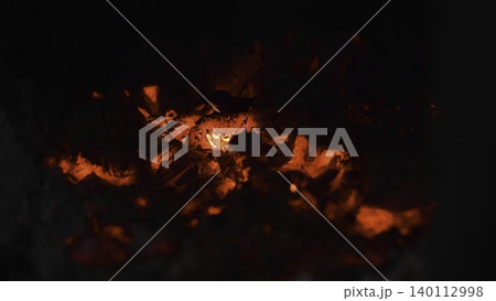 Radiant Charcoal Embers Glow In Smoky Darkness. Hot Ash And Sparks Swirl Around Glowing Charcoal Flames. Media 140112998
