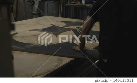 Focused Craftsman Meticulously Positions Complex Starshaped Inlay Within Round Plywood Panel In Workshop . Media 140113011