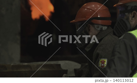 Metalworker Inspecting Surface. Focused Foundry Employee Examining Heated Metal Surface Carefully . Stock clip 140113012