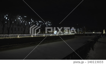 Frozen Water Reflects Festive Lights. Serene Icy Canal With Glowing Bridge And Silent Festivities. Media 140113033