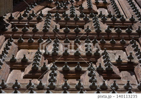 Wooden door with iron spikes in black and white. 140113235