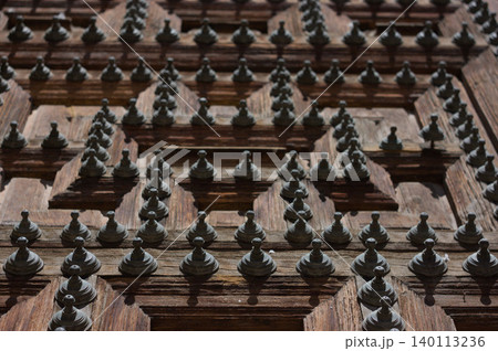 Wooden door with iron spikes in black and white. Wooden door with iron spikes in black and white. 140113236