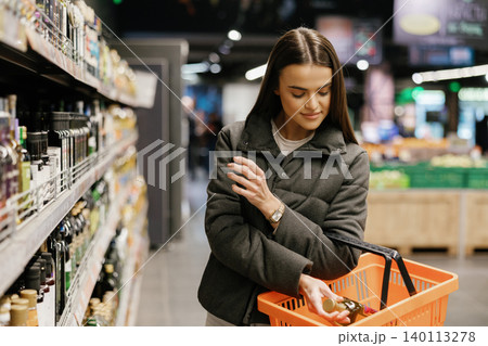Woman shopping for groceries in supermarket aisle Woman shopping for groceries in supermarket aisle 140113278