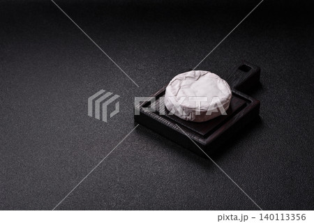 Pink Brie or Camembert cheese with honey, jam, figs, and crackers. Brie cheese 140113356
