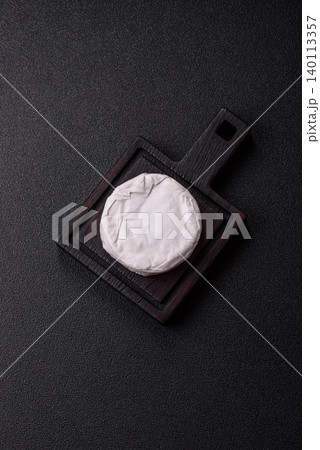 Pink Brie or Camembert cheese with honey, jam, figs, and crackers. Brie cheese 140113357
