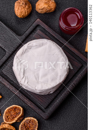 Pink Brie or Camembert cheese with honey, jam, figs, and crackers. Brie cheese Pink Brie or Camembert cheese with honey, jam, figs, and crackers. Brie cheese 140113362