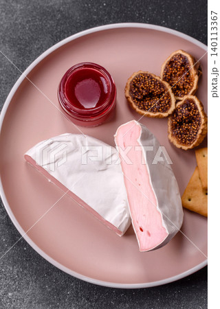 Pink Brie or Camembert cheese with honey, jam, figs, and crackers. Brie cheese Pink Brie or Camembert cheese with honey, jam, figs, and crackers. Brie cheese 140113367