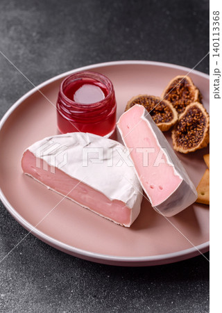 Pink Brie or Camembert cheese with honey, jam, figs, and crackers. Brie cheese Pink Brie or Camembert cheese with honey, jam, figs, and crackers. Brie cheese 140113368