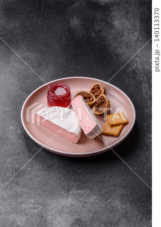 Pink Brie or Camembert cheese with honey, jam, figs, and crackers. Brie cheese Pink Brie or Camembert cheese with honey, jam, figs, and crackers. Brie cheese 140113370