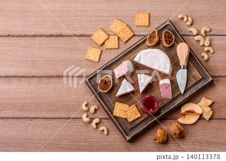 Pink Brie or Camembert cheese with honey, jam, figs, and crackers. Brie cheese Pink Brie or Camembert cheese with honey, jam, figs, and crackers. Brie cheese 140113378