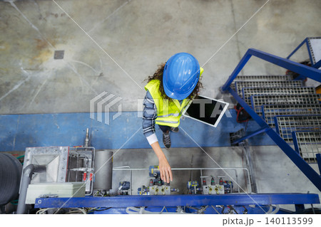 Top view of female worker woring in industrial factory, programming machine. Top view of female worker woring in industrial factory, programming machine. 140113599