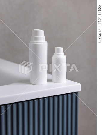 White pump cosmetic bottles mockup on blue bathroom vanity. Skincare cosmetic packaging White pump cosmetic bottles mockup on blue bathroom vanity. Skincare cosmetic packaging 140113688