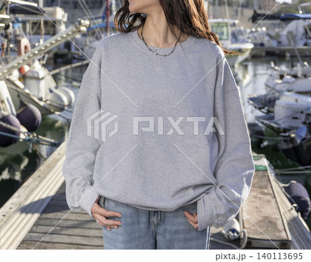 Blank grey oversized unisex sweatshirt mockup on woman near boats and yachts, back copy space 140113695