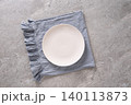 White plate on blue linen napkin top view 140113873