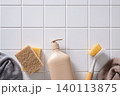 Beige cleaning bottle with brush and sponge on tile background 140113875