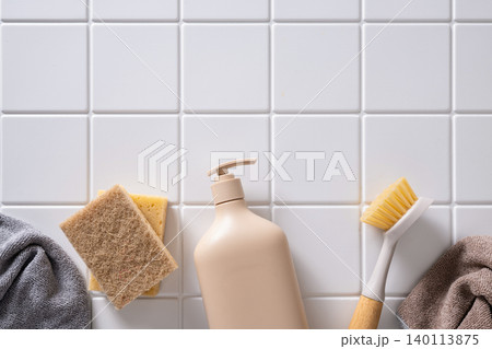 Beige cleaning bottle with brush and sponge on tile background Beige cleaning bottle with brush and sponge on tile background 140113875