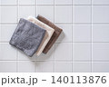 Folded microfiber cloths on white tile background 140113876