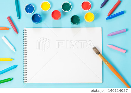 Back to school. Colorful paints, album and brush on punchy blue. 140114027