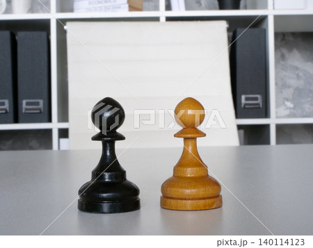 Two chess pawns on office desk for business competition. Two chess pawns on office desk for business competition. 140114123