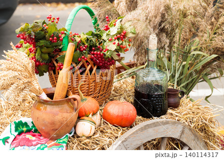 Autumn harvest bounty displayed on a rustic wagon wheel with wine and berries Autumn harvest bounty displayed on a rustic wagon wheel with wine and berries 140114317