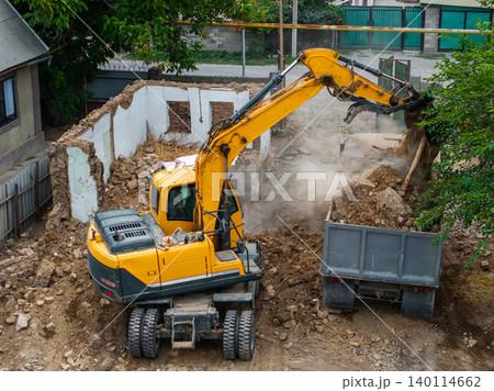 Excavator Clearing Debris at Demolition Site Excavator Clearing Debris at Demolition Site 140114662