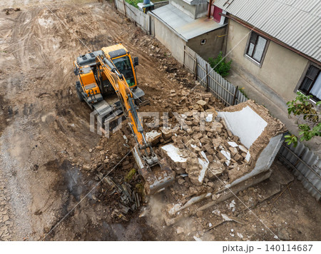 Excavator Demolishing Small Building at Construction Site 140114687