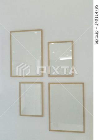 Empty wooden poster frames hanging on white wall gallery mockup template Empty wooden poster frames hanging on white wall gallery mockup template 140114795