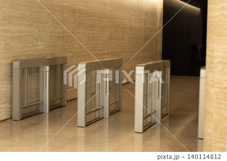 Security turnstiles with glass panels in modern corporate lobby entrance 140114812