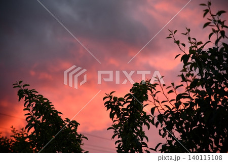 Remote view of helicopter silhouette on background of vivid sundown sky over city in evening Remote view of helicopter silhouette on background of vivid sundown sky over city in evening 140115108